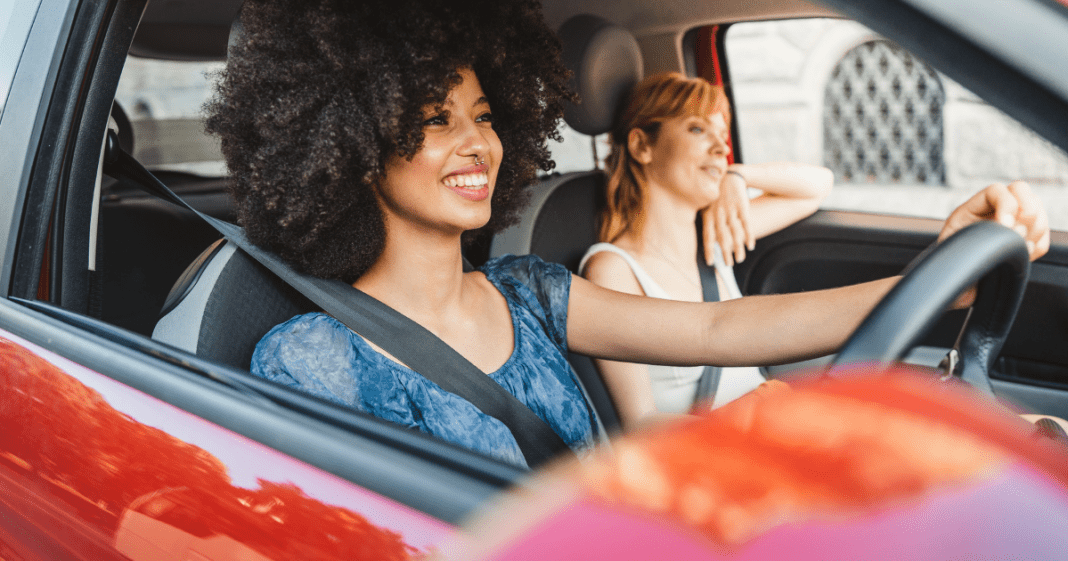 2 ladies in car, smiling and looking ahead